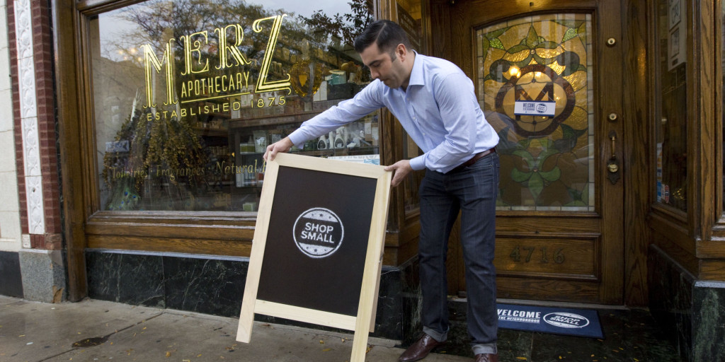 IMAGE DISTRIBUTED FOR AMERICAN EXPRESS OPEN - The owner of Merz Apothecary in Chicago prepares for the increase of traffic expected on Small Business Saturday after a front window makeover thanks to designer Simon Doonan. (John Konstantaras / AP Images for American Express OPEN)
