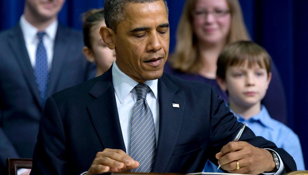 President Barack Obama signs executive orders outlining proposals to reduce gun violence, Wednesday, Jan. 16, 2013, in the South Court Auditorium at the White House in Washington. (AP Photo/Carolyn Kaster)